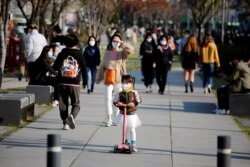 ក្មេង​ស្រី​ម្នាក់​ពាក់ម៉ាស​ការ​ពារ​ការ​ឆ្លង​ជំងឺ​កូវីដ១៩ កំពុង​ជិះ​ប្រដាប់​សម្រាប់​ជិះ​ធ្វើ​ពី​ជ័រ នៅ​សួន​ច្បារ​មួយ​នៅ​ទីក្រុង​សេអ៊ូល ប្រទេស​កូរ៉េ​ខាង​ត្បូង កាល​ពី​ថ្ងៃ​ទី​៣ មេសា ២០២០។