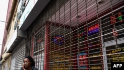 A woman outside a closed nail parlour and spa salon in downtown Atlanta, Georgia, on April 23, 2020, where the governor takes a massive gamble by allowing businesses like gyms and hair salons to re-open