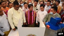 缅甸联邦选举委员会成员在仰光展示未来选举中将使用的投票机。(法新社：2023年9月5日)