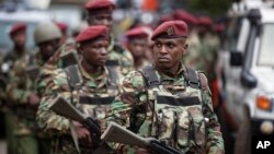 Kenyan security forces walk from the scene as continued blasts and gunfire could be heard early Wednesday, Jan. 16, 2019, in Nairobi, Kenya.