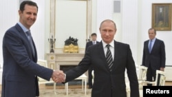Russian President Vladimir Putin (R) shakes hands with Syrian President Bashar al-Assad during a meeting at the Kremlin in Moscow, Russia, October 20, 2015.