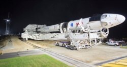 In this Monday, Nov. 9, 2020 photo provided by NASA, a SpaceX Falcon 9 rocket and Crew Dragon capsule is rolled out of the horizontal integration facility at Launch Complex 39A, as preparations continue for a crewed mission at NASA's Kennedy Space Center