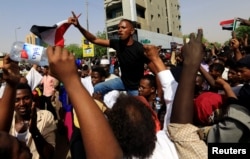 Sudanese demonstrators protest against the army's announcement that President Omar al-Bashir would be replaced by a military-led transitional council, in Khartoum, April 11, 2019.