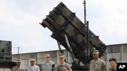 FILE - U.S. Pacific Command Commander Adm. Harry Harris, third from right, answers a reporter's question during a press conference in front of PAC-3 launching station at Osan Air Base in Pyeongtaek, South Korea, Aug. 22, 2017.