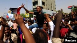 Demonstran Sudan meneriakan slogan-slogan dalam unjuk rasa memprotes pengumuman pihak militer bahwa dewan transisi pimpinan militer, di Khartoum, 11 April 2019. 