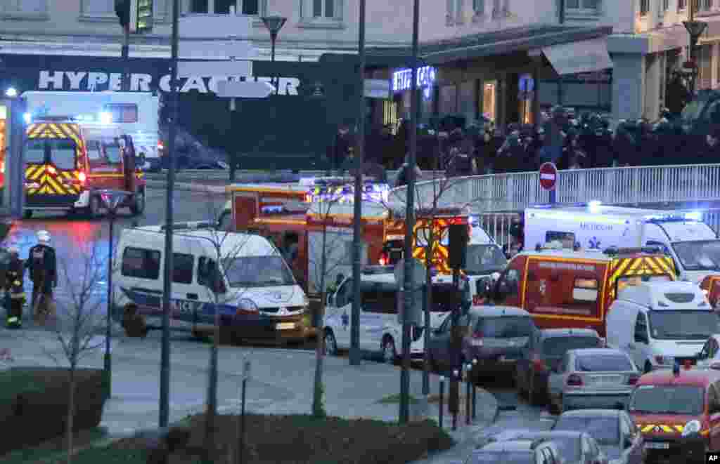Police officers storm the kosher grocery store where a gunman held several hostages, in Paris, Jan. 9, 2015. 