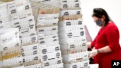 Stacks of ballots await to be counted for the general election inside the Maricopa County Recorder's Office in Phoenix, Nov. 6, 2020.