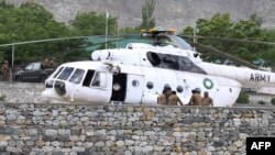 Tentara Pakistan berkumpul di samping sebuah helikopter angkatan bersenjata di rumah sakit militer di mana korban kecelakaan dibawa untuk perawatan di Gilgit (8/5).