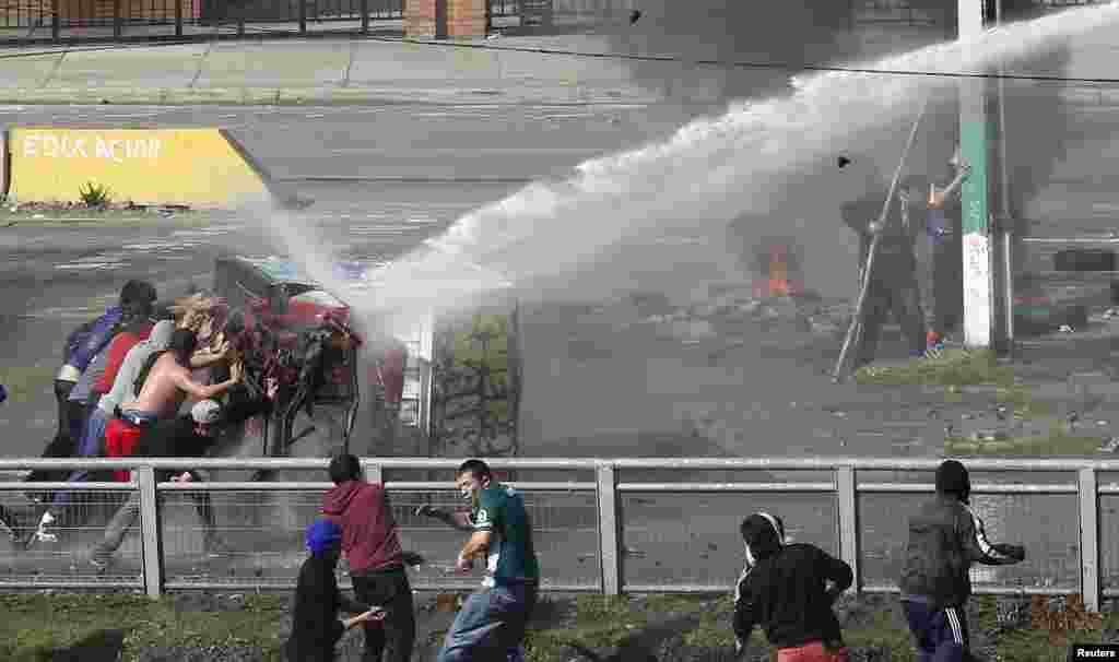Para nelayan bentrok dengan polisi anti huru-hara pada aksi protes di kota Valparaiso, Chile.