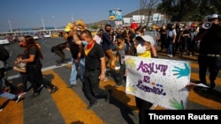 Emigrantë dhe aktivistë të të drejtave të njeriut protestojnë në pikën kufitare në San Ysidro, Tijuana