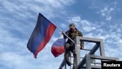 우크라이나군 병사가 1일 도네츠크 주 리만 시내 구조물에 게양돼있던 친러 세력 도네스크인민공화국(DPR)기를 철거하고 있다. (자료사진)