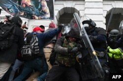 Polisi antihuru-hara memukul mundur kerumunan pendukung Presiden AS Donald Trump setelah mereka menyerbu Gedung Capitol AS pada 6 Januari 2021 di Washington, DC. (Foto: AFP)