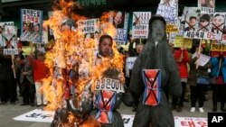 Warga Korsel menggelar aksi protes anti Korut di Seoul, Korut (15/4) dengan membakar patung bergambar para pemimpin Korut Kim Jong-un, mendiang Kim Jong-il dan Kim Il-sung saat Korut merayakan ulang tahun mendiang Kim Il-sung.