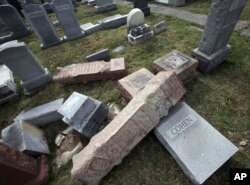 Damaged headstones rest on the ground at Mount Carmel Cemetery, Feb. 27, 2017, in Philadelphia. More than 100 headstones have been vandalized at the Jewish cemetery in Philadelphia.