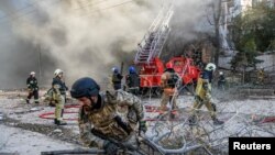 მეხანძრეები კიევში დრონით აფეთქებული შენობიდან ქალის გამოყვანას ცდილობენ. უკრაინა, 17 ოქტომბერი, 2022 წ. 