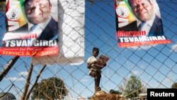 A Zimbabwean opposition party Movement For Democratic Change (MDC) supporter holds a party newsletter at an election rally about 90 km (56 miles) east of the capital Harare, Zimbabwe, July 23, 2013.