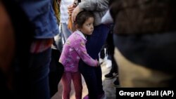 Nikol Hernandes iz Meksika drži se čvrsto za svoju majku, dok čeka sa drugim porodicama da se prijavi za politički azil u SAD u Tihuani, blizu granice, 13. juna 2018. 