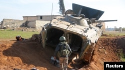 Pobunjenički borac hoda u blizini vojnog vozila u Menaghu, sjeverno od Alepa, Sirija, 2. decembra 2024.