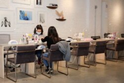 A customer is worked on by a nail technician at Akiko Nails, a business that the owner says has been greatly affected by the outbreak of the coronavirus disease, in Manhattan, New York City, New York, March 18, 2020.