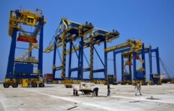 This Aug. 9, 2017 photo shows construction workers in the port of the northern city of Tripoli, Lebanon.