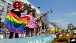 Gay and lesbian rights activists demonstrate as participants of the annual Gay Pride parade wave from a float in Kyiv, Ukraine, June 18, 2017. 