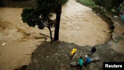 People recover some zinc sheets after a mudslide damaged their homes during heavy rains by Tropical Storm Nate in San Jose, Costa Rica, Oct. 5, 2017.