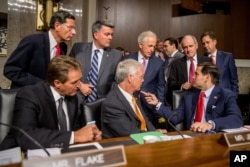 FILE - Members of the Senate committee speak together before Secretary of State John Kerry, Secretary of Energy Ernest Moniz and Secretary of Treasury Jack Lew arrive to testify at a Senate Foreign Relations Committee hearing on Capitol Hill, in Washington, July