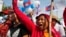 Cambodian garment workers shout slogans during a gathering to mark May Day celebrations in Phnom Penh, Cambodia, Friday, May 1, 2015. Garment workers staged a rally to demand higher wage and better working condition. The placard at right in the background reads: "Demanding the government urgently set up the labor court." (AP Photo/Heng Sinith)