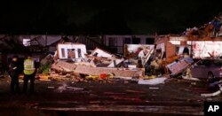 Police stand at the ruins of a hotel in El Reno, Okla., Sunday, May 26, 2019, following a likely tornado touchdown late Saturday night.