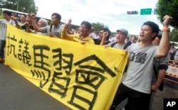 Opposition protesters shout slogans behind a banner opposing the planned meeting of Taiwan's President Ma Ying-jeou with his China counterpart Xi Jinping in Taipei, Taiwan, Nov. 4, 2015.