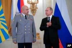 FILE - Russian President Vladimir Putin, right, applauds Col. Gen. Sergei Surovikin during an awards ceremony for troops who fought in Syria, in the Kremlin, in Moscow, Dec. 28, 2017.