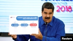 Venezuela's President Nicolas Maduro holds a banner explaining the new minimum wage as he speaks during a news conference in Caracas, Venezuela, April 30, 2018. 
