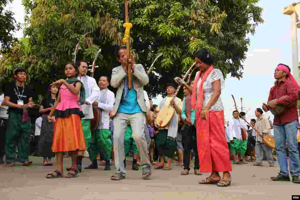 សិល្បៈករ​ចាប៉ី​ដងវែង​មួយចំនួន​រាំ​​​នៅ​ពេល​មាន​ការសម្ដែង​តន្រ្តីប្រពៃណីខ្មែរ​​មួយ​បទ​ ប្រហែល​ប៉ុន្មាន​នាទី​មុន​នឹង​មហោស្រព​ចាប៉ី​ចាប់ផ្ដើម​នៅ​សាល​មហោស្រព​ចតុមុខ​នារាជធានី​ភ្នំពេញ​កាលពីថ្ងៃ​អាទិត្យសប្ដាហ៏​មុន។​ (​ឡេង ឡែន/VOA)