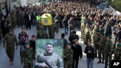Hezbollah fighters, center, carry the coffin of their commander Ali Bazzi who was killed in Syria,Dec. 9, 2013. (AP Photo/Mohammed Zaatari)