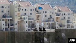 Anggota pasukan keamanan Israel menembakkan gas air mata di desa Bilin, dekat kota Ramallah, Tepi Barat. (Foto: AFP)