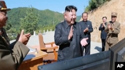 This image made from video aired by North Korea's KRT, July 4, 2017, shows what was said to be North Korea leader Kim Jong Un, center, applauding after the launch of a Hwasong-14 intercontinental ballistic missile in North Korea's northwest.