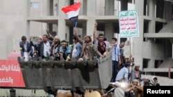 Followers of the Shi'ite Houthi movement ride a bulldozer they took from riot police during clashes along a main road leading to the airport in Sana'a Sept. 7, 2014.