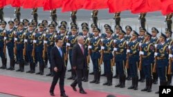 Australian Prime Minister Malcolm Turnbull, center right, walks with Chinese Premier Li Keqiang, during a welcome ceremony outside the Great Hall of the People in Beijing, China, April 14, 2016. 