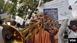 Seorang anggota sekte global Hare Krishna memainkan terompetnya selama protes di luar konsulat Rusia di Kolkata (19/12). Parlemen India dan pengunjuk rasa berkumpul di luar konsulat Rusia menentang pelarangan kitab Bhagavad Gita.