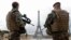 FILE - French army paratroopers patrol near the Eiffel tower in Paris, France, March 30, 2016. French authorities are extending a state-of-emergency they imposed after the November 2015 terror attacks that killed 130 people.