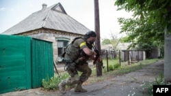 Tentara pemerintah Ukraina mengusung senjata di Marinka, Donetsk.
