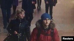 ជន​សង្ស័យ​ Akbarzhon Jalilov (Dzhalilov) ពាក់អាវ​ក្រហម កំពុង​ដើរ​នៅ​ក្នុង​ស្ថានីយ៍​រថភ្លើង​ក្រោម​ដី​នៅ​ក្នុង​ទីក្រុង​ St Petersburg ប្រទេស​រុស្ស៊ី។