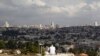 A view of Jerusalem is seen in the background as a man sits in Giv'at HaMatos, a neighborhood on the southern fringes of Jerusalem's city limits where Israel has decided to move forward on a settler housing project, Oct. 2, 2014. 