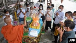 ប្រជាពលរដ្ឋកម្ពុជាប្រគេនម្ហូបនិងបច្ច័យដល់ព្រះសង្ឃ នៅវត្តមួយក្នុងខេត្តព្រៃវែង នារដូវបុណ្យភ្ជុំ កាលពីថ្ងៃទី ៥ ខែតុលា ឆ្នាំ២០២១។ 