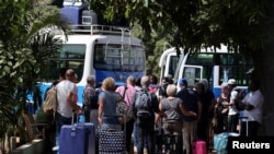 Des touristes se sont réunis pour monter dans des bus et aller à l'aéroport, à Banjul, en Gambie, le 18 janvier 2017.