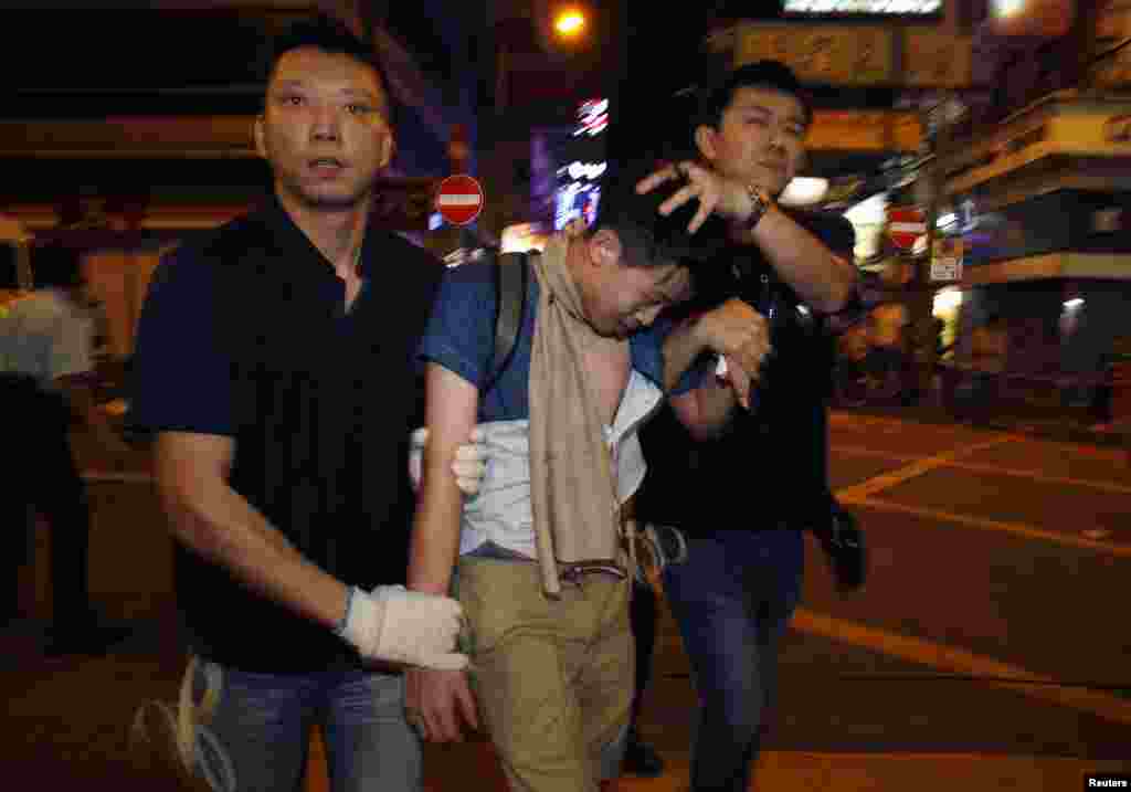 Policemen detain a pro-democracy demonstrator during a confrontation at the Mong Kok shopping district in Hong Kong, Nov. 26, 2014.