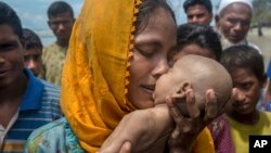 Seorang perempuan Muslim Rohingya Hanida Begum, mencium bayinya Abdul Masood yang tewas dalam perjalanan dari Myanmar untuk mencapai Shah Porir Dwip, Bangladesh, Kamis (14/9). 