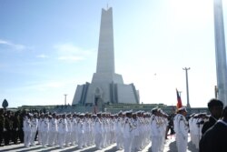 រូបឯកសារ៖ កង​កម្លាំង​ទាហាន​ស្លៀកពាក់​ស​ កំពុង​ឈរ​នៅ​ខាង​ក្រោម​វិមាន​នយោបាយ​ឈ្នះ-ឈ្នះ​នាពិធី​សម្ពោធ​វិមាន​នយោបាយ​ឈ្នះ​-​ឈ្នះ នៅថ្ងៃទី២៨ ខែធ្នូ ឆ្នាំ២០១៨។ (គី ម៉េងលី/វីអូអេ)