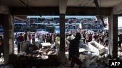 2024년 9월 11일 가자지구 중부 누세이라트에서 이스라엘 공습으로 파괴된 건물 주변에 팔레스타인 사람들이 모여있다.