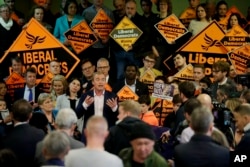 FILE - Tim Farron, center left, the leader of the Liberal Democrats party, speaks during a campaign event to announce his party today passed 100,000 members, in a church hall in the Vauxhall area of London, Monday, April 24, 2017.